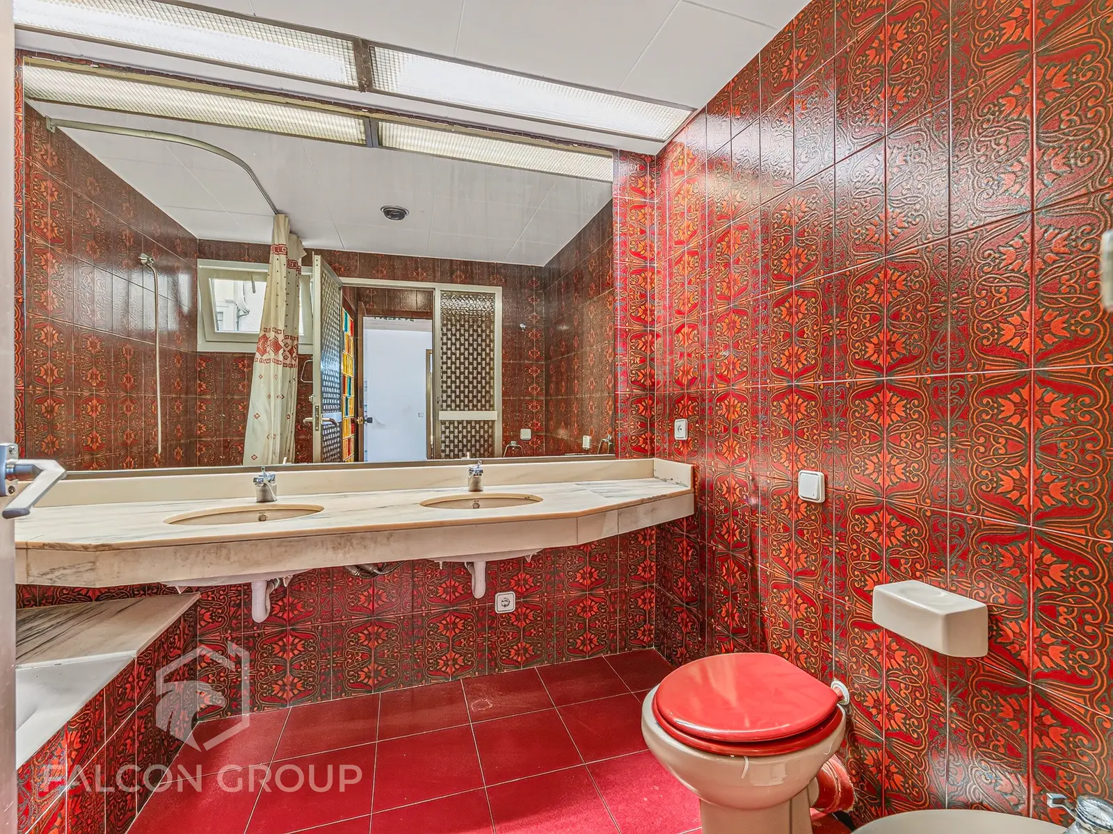 Baño con azulejo rojo estampado y encimera de mármol, fotografía inmobiliaria de Visoria