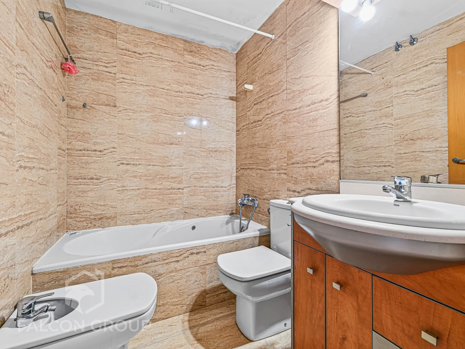 Baño revestido en travertino con bañera