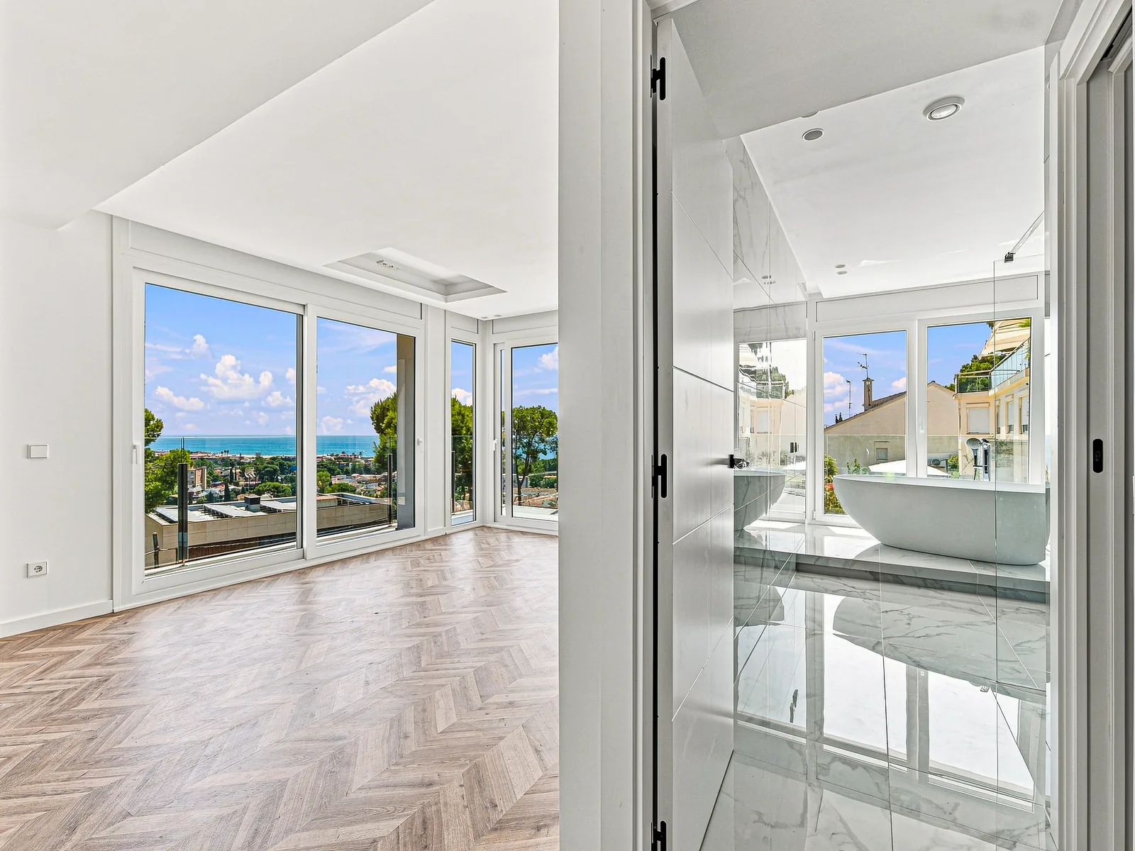 Suite con ventanales al mar y bañera exenta al fondo, villa en Castelldefels