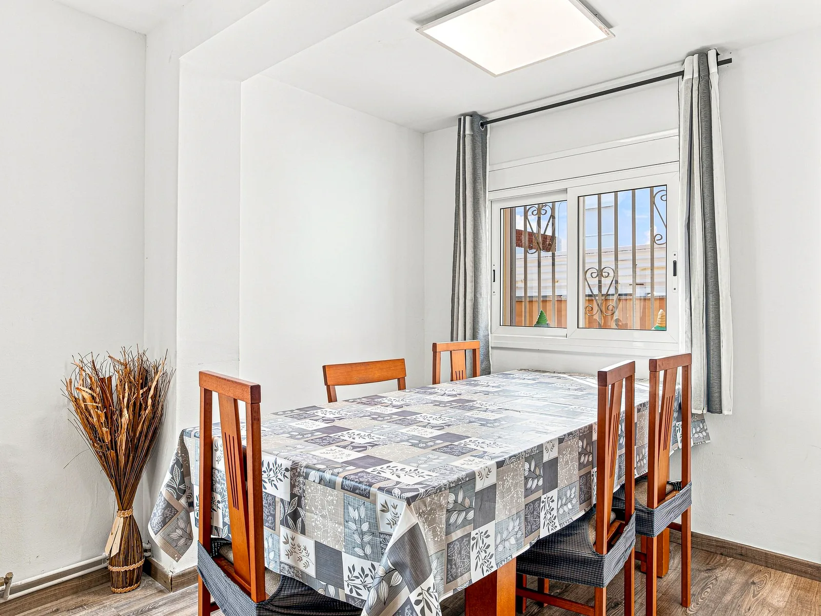 Comedor con mesa de madera y ventana al patio, fotografía inmobiliaria de Visoria
