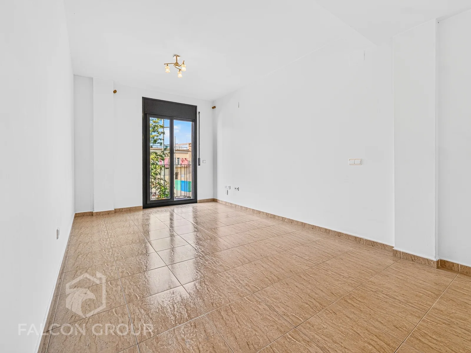 Estancia vacía con salida a balcón, piso listo para reformar